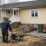 Svensk villa med trädgård där en person rakar torrt gräs till en kärra